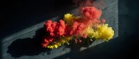 Vibrant red and yellow ink clouds dispersing in dark water creating abstract fluid art patterns for creative design projects.