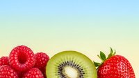 Fresh mixed fruits including raspberries, kiwi slice and strawberry on gradient background for healthy eating and nutrition concepts.