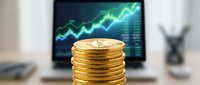Stack of golden coins with upward trending financial chart on computer monitor in blurred background, representing investment growth and financial success for business and wealth management.
