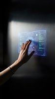Hand touching futuristic holographic interface with digital data visualization and circuit patterns on dark wall for technology presentations.