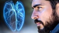 Caucasian bearded man in profile view next to glowing blue holographic heart model showing detailed cardiovascular system and arterial network visualization for medical concept.