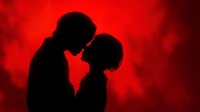Romantic couple silhouettes touching foreheads in intimate moment against dramatic red background for Valentine's Day and love concepts.