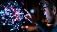 Young Caucasian man in glasses interacting with glowing blue and pink digital hologram visualization against dark background, futuristic technology concept.