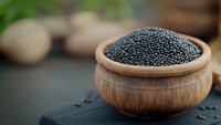 Black caviar in wooden bowl on dark background, luxury gourmet food close up with selective focus and copy space for restaurant menu design.