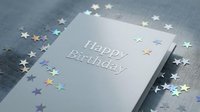 Silver Happy Birthday card with holographic star confetti on gray fabric background, elegant celebration greeting for party invitations.