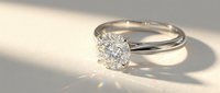Elegant solitaire diamond engagement ring with brilliant cut stone on twisted white gold band casting soft shadows on neutral background.