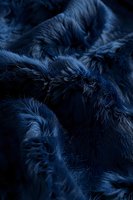 Luxurious dark blue faux fur texture with soft waves and deep shadows creating an elegant abstract pattern, suitable for fashion and interior design backgrounds.