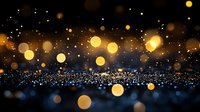 Magical glowing golden bokeh lights and sparkles on dark background with blurred glitter effect creating dreamy atmospheric scene for festive designs.