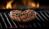 Juicy grilled beef steak with herbs and spices on barbecue grill with flames in background. Perfect for food advertising and menu design.