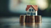 Small model house placed on stacked coins against blurred background, representing real estate investment, property market, mortgage, and home savings concept.