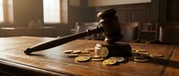 Wooden judge gavel with golden coins on courtroom desk symbolizing legal decisions, financial justice, and monetary disputes in warm sunlight.