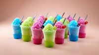 Colorful frozen slushie drinks with straws arranged on neutral background, ready for summer beverage, party, and refreshment design projects.