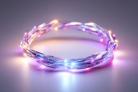 Glowing LED string lights forming circular shape with purple and blue illumination on reflective surface creating magical ambient atmosphere.