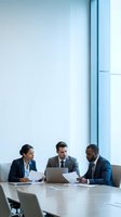 Diverse business team of three professionals collaborating in modern office meeting room with laptop and documents for corporate strategy planning.