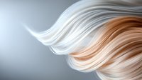 Flowing strands of platinum blonde and peach colored hair creating elegant waves against soft gray background, showcasing natural movement and texture.