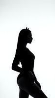 Silhouette of a young woman with devil horns posing against a white background, dark dramatic contrast for Halloween or fantasy concepts.