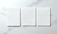 Three blank white rectangular paper sheets arranged horizontally on marble surface background, isolated mockup for branding and design presentations.