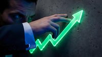 Businessman in suit touching glowing neon green upward arrow chart on concrete wall, symbolizing financial growth, profit increase, and business success for corporate presentations.