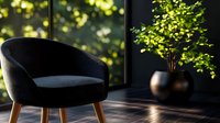 Modern dark blue velvet armchair with wooden legs in contemporary living room with large windows and natural sunlight filtering through green foliage.
