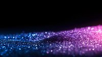 Magical glowing particles with blue and pink bokeh light effect on black background, creating dreamy abstract cosmic atmosphere for design projects.