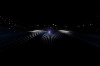 Futuristic light rays spreading across dark horizon with glowing particles and streaks creating dramatic perspective effect for technology backgrounds.