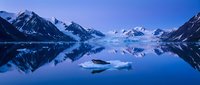 Serene alpine lake with snow-capped mountain peaks reflected in still blue waters at dawn, showcasing pristine wilderness landscape for travel and nature projects.