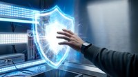 Businessman hand touching glowing shield icon on digital screen, representing cybersecurity, data protection, and network security solutions for enterprise systems.