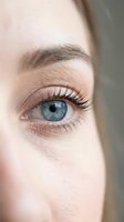 Close-up of woman's blue eye with natural makeup and long eyelashes. Beauty, skincare and cosmetics concept for advertising and wellness content.