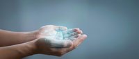 Cupped hands holding glowing digital globe with network connections representing global technology, communication and worldwide connectivity concepts.
