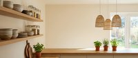 Modern minimalist kitchen interior with wooden shelves, ceramic dishes, potted herbs on windowsill and natural wicker pendant lights for home design.