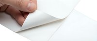 Hand holding corner of blank white paper sheet, peeling back edge to reveal clean surface underneath. Suitable for stationery, office supplies, and design mockup projects.
