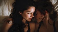 Intimate couple lying together in bed sharing tender moment with soft natural lighting creating romantic atmosphere for relationship and love concepts.