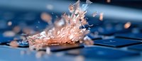 Metal welding sparks flying from steel surface with bright orange flames and particles scattered on industrial workshop floor creating dramatic lighting effects.