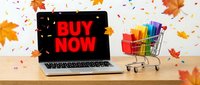 Laptop with buy now text on screen next to colorful shopping cart, autumn leaves and confetti flying, fall sale concept.