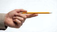 Hand holding yellow pencil with sharp tip against white background, isolated for design use on educational materials, presentations, and creative projects.