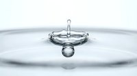 Water drop splash captured in macro with crown formation and ripples on light background, showcasing liquid motion and purity.