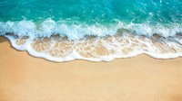 Aerial view of turquoise ocean waves crashing on golden sandy beach with white foam, creating natural pattern where water meets shore. Perfect for travel and summer designs.