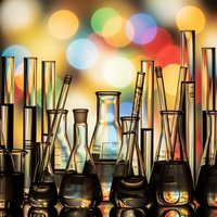 Laboratory glassware collection with colorful bokeh lights background for scientific research and chemistry experiments in modern lab setting.