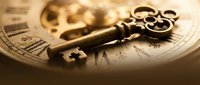 Vintage brass key with ornate handle resting on antique pocket watch and old documents creating nostalgic steampunk atmosphere for mystery concepts.