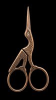 Ornate bronze crane-shaped embroidery scissors with detailed feather etching, long pointed blades, and decorative handles isolated on transparent background. Ready for clipart, print-on-demand, sublimation, and craft design projects.
