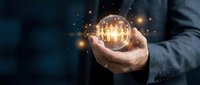 Businessman holding glowing light bulb with sparkling particles, representing innovation, creativity, and bright ideas for business solutions and success.