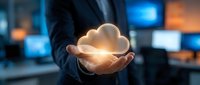 Businessman holding glowing cloud computing icon in hands with digital technology background for data storage and network solutions.