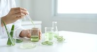 Natural aloe vera skincare preparation with fresh plant extract being mixed in glass container for homemade cosmetic treatment and beauty routine.