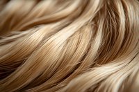 Close-up of wavy blonde hair with highlights showing natural texture and shine, useful for beauty, haircare, and salon advertising.