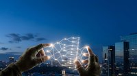 Hands holding glowing network connections over city skyline at dusk representing digital communication technology and global connectivity solutions.