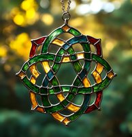 Celtic knot stained glass suncatcher with emerald green and ruby red elements against blurred golden bokeh background, creating mystical ornamental pattern.
