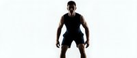 Athletic male athlete in ready stance wearing black sleeveless shirt and shorts, isolated on white background for sports and fitness design projects.