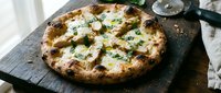 Freshly baked pizza with melted cheese and herbs on dark slate board, ready for serving. Perfect for food blogs, restaurants, and culinary content.