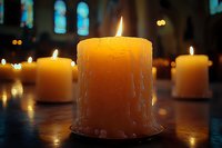 Warm glowing candles create peaceful atmosphere in church interior with stained glass windows. Spiritual meditation and prayer concept for religious ceremonies.