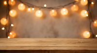 Empty wooden table with warm string lights creating cozy ambiance against blurred background for product display and festive decoration concepts.